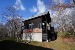 a small house with a black roof at Goodfellas Onsen House in Niseko