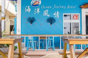 a restaurant with a blue wall and tables and chairs at Ocean B&B in Xiaoliuqiu