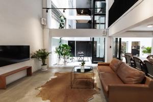 a living room with a couch and a tv at Chocolate box mint - SHA Plus in Bangkok