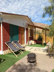 une maison avec 2 chaises longues et un barbecue dans la cour dans l'établissement El pimiento Horcon valle elqui, 4 personas, à La Serena