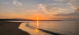 a sunset on a beach with the sun setting at Casa Lora, camino a las playas. in Puerto Jiménez