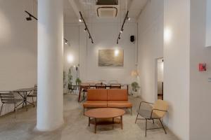 a room with a couch and tables and chairs at Chocolate box mint - SHA Plus in Bangkok