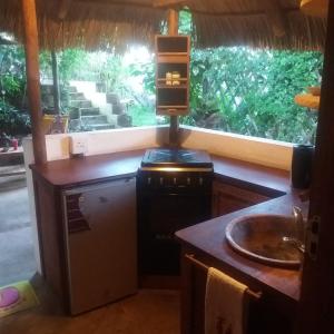 - une cuisine avec un évier et un comptoir avec une fenêtre dans l'établissement Casa Camaleao Gekko Cottadge, à Praia do Tofo
