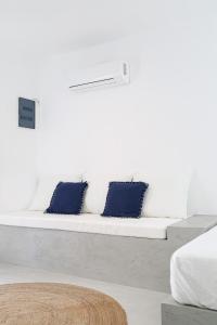białą kanapę z dwoma niebieskimi poduszkami w obiekcie 30villa Rd Studio w mieście Rodos