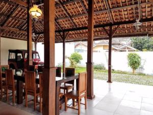 ボゴールにあるnDalem Julang Bogor - Javanese House 2Bedroomのダイニングルーム(テーブル、椅子、トラクター付)