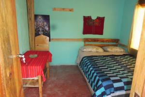 a small bedroom with a bed and a table at Casa Deja-vu in San Marcos La Laguna