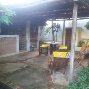 eine Terrasse mit einem Tisch, Stühlen und einem Tisch in der Unterkunft Casa Camaleao Gekko Cottadge in Praia do Tofo
