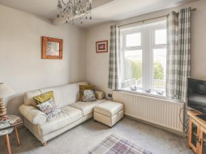a living room with a couch and a window at Strawberry Cottage in Haworth