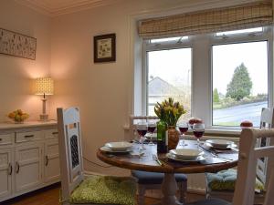 a dining room with a table with wine glasses at Strawberry Cottage in Haworth