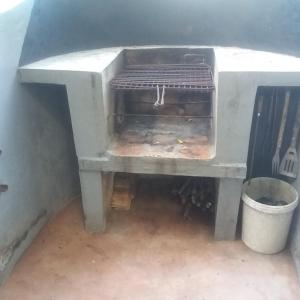 a stone oven with a trash can next to it at Casa Camaleao Gekko Cottadge in Praia do Tofo