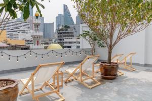 a row of chairs and a tree on a rooftop at Chocolate box mint - SHA Plus in Bangkok