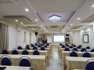 une salle de conférence avec des chaises et un écran de projection dans l'établissement Thien Ha Hotel, à Thu Dau Mot
