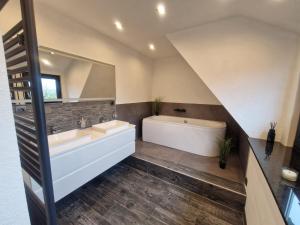 a bathroom with two sinks and a tub and a mirror at Ferienwohnung am See Dillich - Schwimmteich - Eigener Garten - Ruhige Lage - Hunde willkommen in Borken