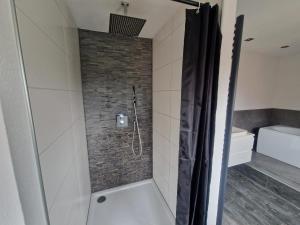a bathroom with a shower with a brick wall at Ferienwohnung am See Dillich - Schwimmteich - Eigener Garten - Ruhige Lage - Hunde willkommen in Borken