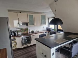 a kitchen with white cabinets and a black counter top at Ferienwohnung am See No.1 in Borken