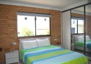 a bedroom with a bed and two windows at Seacrest 5 South West Rocks in South West Rocks