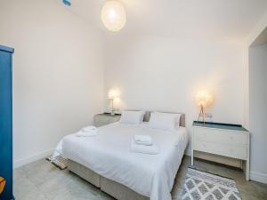 ein weißes Schlafzimmer mit einem großen Bett und zwei Nachttischen in der Unterkunft Alexander Z - Uk43586 in Ellesmere