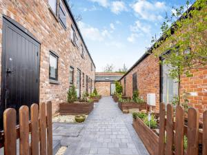 a brick alley with a black door and wooden fences at Alexander Z - Uk43586 in Ellesmere