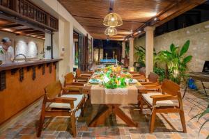 een eetkamer met een lange tafel en stoelen bij Maycasa Villa - Private pool 4BR in Da Nang