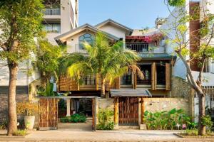 een huis met palmbomen voor een gebouw bij Maycasa Villa - Private pool 4BR in Da Nang