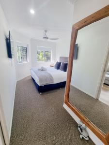 a bedroom with a bed and a mirror at Stunning 2 BR, 2 Bathroom Beachfront Apartment Close To Everything! in Hervey Bay