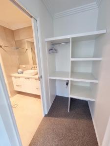 um closet com um lavatório e um espelho em Stunning 2 BR, 2 Bathroom Beachfront Apartment Close To Everything! em Hervey Bay