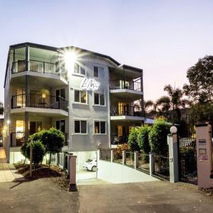 un edificio con un coche aparcado delante de él en Stunning 2 BR, 2 Bathroom Beachfront Apartment Close To Everything! en Hervey Bay