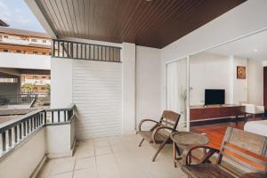 a room with a balcony with chairs and a television at The Dale Pattaya Boutique and Spa in Pattaya South