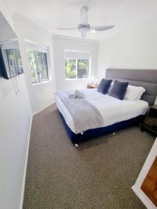 een slaapkamer met een groot bed en 2 ramen bij Stunning 2 BR, 2 Bathroom Beachfront Apartment Close To Everything! in Hervey Bay