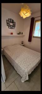 a bedroom with a bed with a comforter on it at Coquet Rez jardin plage parking wifi in Saint-Mandrier-sur-Mer