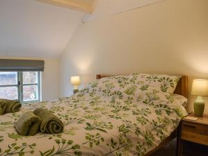 1 dormitorio con 1 cama con colcha verde en Drapers Cottage en Foxton