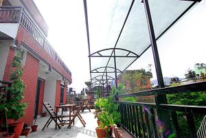 einen Balkon mit Stühlen und einem Tisch auf einem Gebäude in der Unterkunft Hotel Bubo Himalaya in Kathmandu