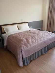 una camera da letto con un grande letto con lenzuola e cuscini bianchi di Lohas Seaview B&B a Beigan