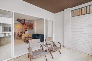 a living room with chairs and a couch and a staircase at The Dale Pattaya Boutique and Spa in Pattaya South