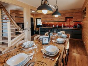a dining room with a wooden table with plates and wine glasses at Jaworki Prestige SPA in Jaworki