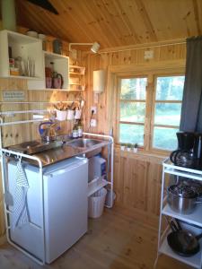 Il comprend une cuisine équipée d'un évier et d'une cuisinière. dans l'établissement Countrycabin Bergslagen stuga, à Ramsberg