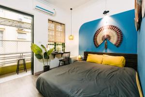 une chambre avec un lit et un mur bleu dans l'établissement Anchie Home Lý Nam Đế- Ha Noi Train Street- Ha Noi Old Quarter, à Hanoï