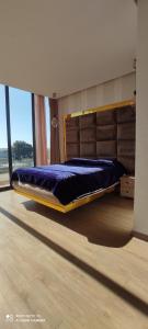 uma cama grande num quarto com uma janela grande em Villa à bahia golf beach em Kasba Bou Hamira