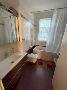 a bathroom with a tub and a toilet and a sink at Kasia porta sul mare di Livorno Free parking in Livorno