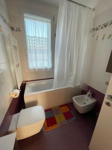 y baño con bañera, aseo y lavamanos. en Kasia porta sul mare di Livorno Free parking, en Livorno