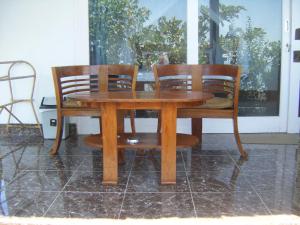 a wooden table and two chairs around a table at Alur Beach Homestay in Amed