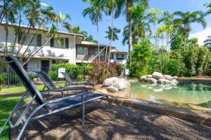 a yard with two chairs and a pond at Seascape Holidays at Reef Terraces on St Crispins in Port Douglas