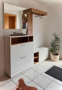 baño con armario blanco y espejo en Eifelhaus LandLuft mit Infrarotkabine en Berlingen