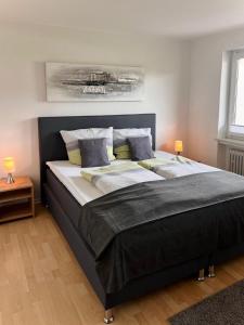 a large bed in a bedroom with two lamps at Eifelhaus LandLuft mit Infrarotkabine in Berlingen
