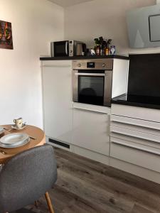 kuchnia z kuchenką, stołem i krzesłem w obiekcie Eifelhaus LandLuft mit Infrarotkabine w mieście Berlingen