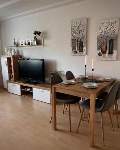ein Esszimmer mit einem Tisch mit Stühlen und einem TV in der Unterkunft Eifelhaus LandLuft mit Infrarotkabine in Berlingen