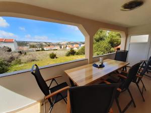 a dining room with a table and chairs and a large window at Apartment Ena in Stara Novalja