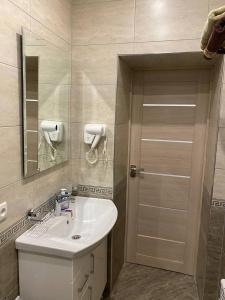 a bathroom with a sink and a mirror and a door at Crown Samarkand in Samarkand