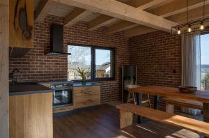 une cuisine avec une table et un mur en briques dans l'établissement Apartmán Nežichov 2 U Polocka, à Toužim