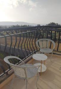 a balcony with two chairs and a table at Spacious and Serene 1 bedroom apartments with a lake view and town view in Nakuru